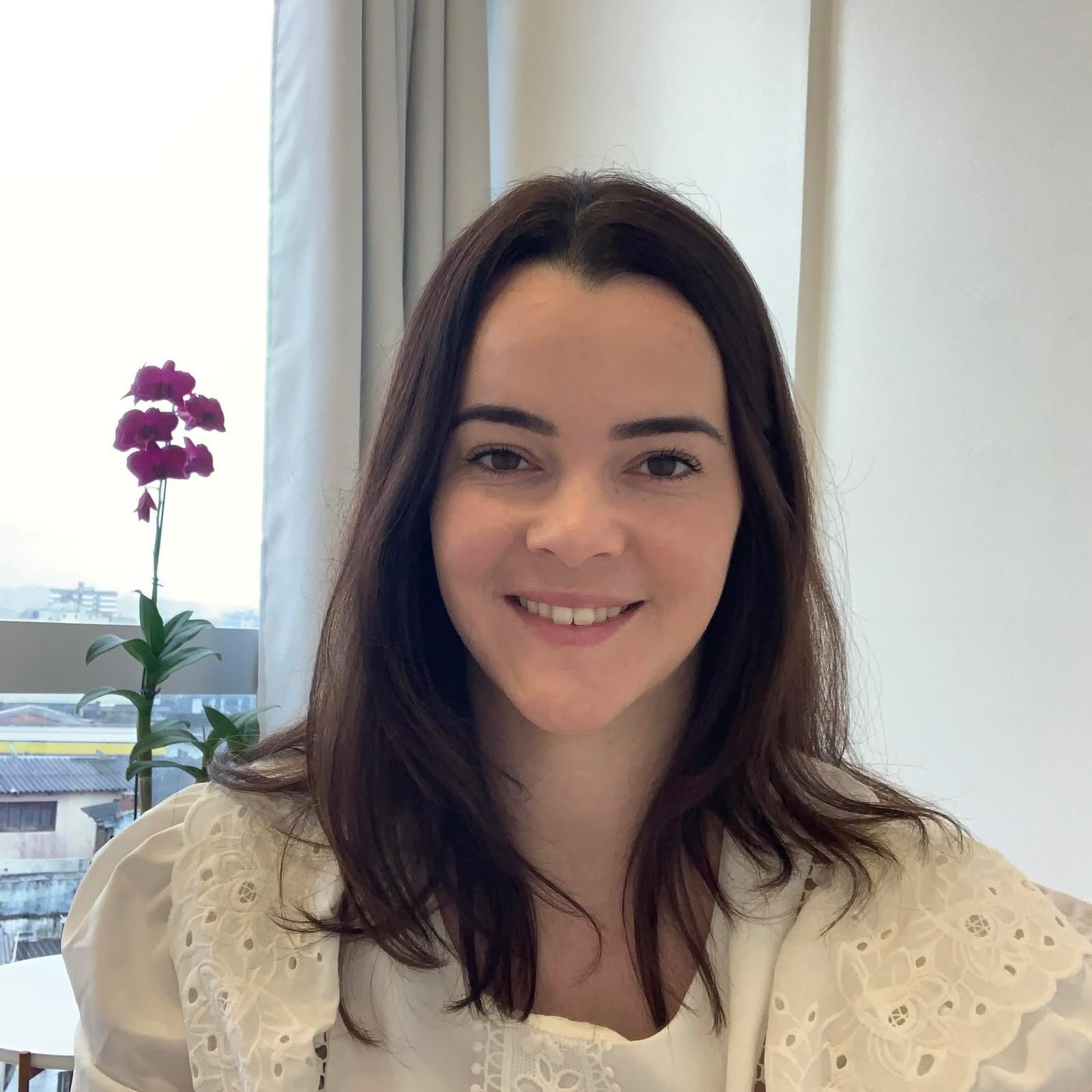 Psicóloga Joyce Santos sorrindo em seu consultório